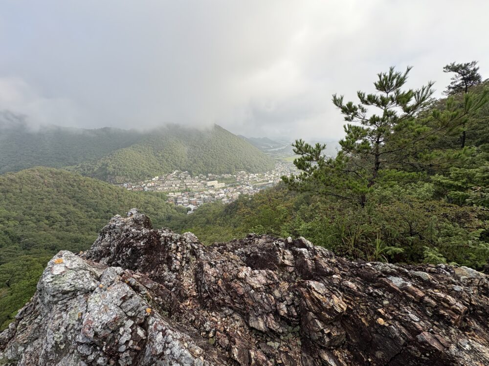 三峰山の岩場から見える周囲の山と市街地